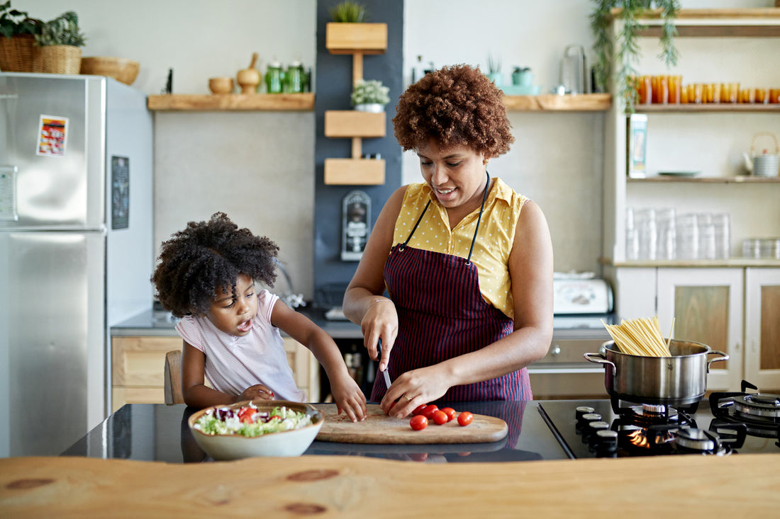 Mom and daughter cooking in a bright, organized kitchen that incorporates our kitchen design tips