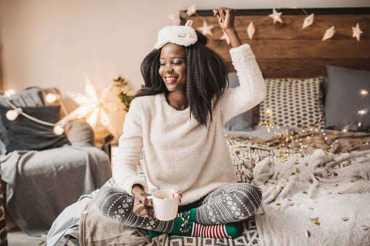 Woman sitting on her bed in a cozy bedroom