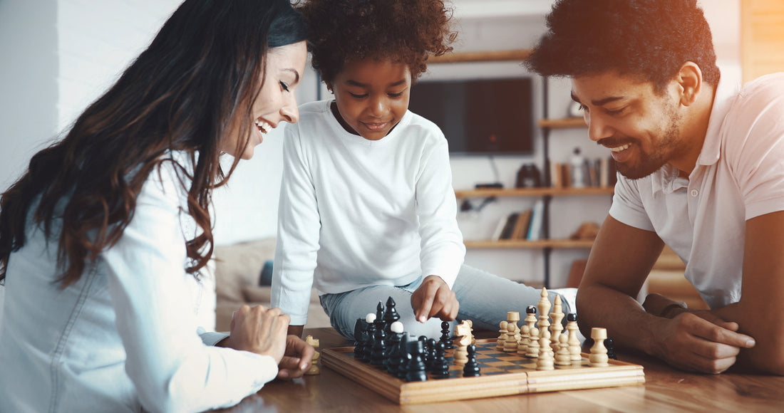 family playing chess in a game room