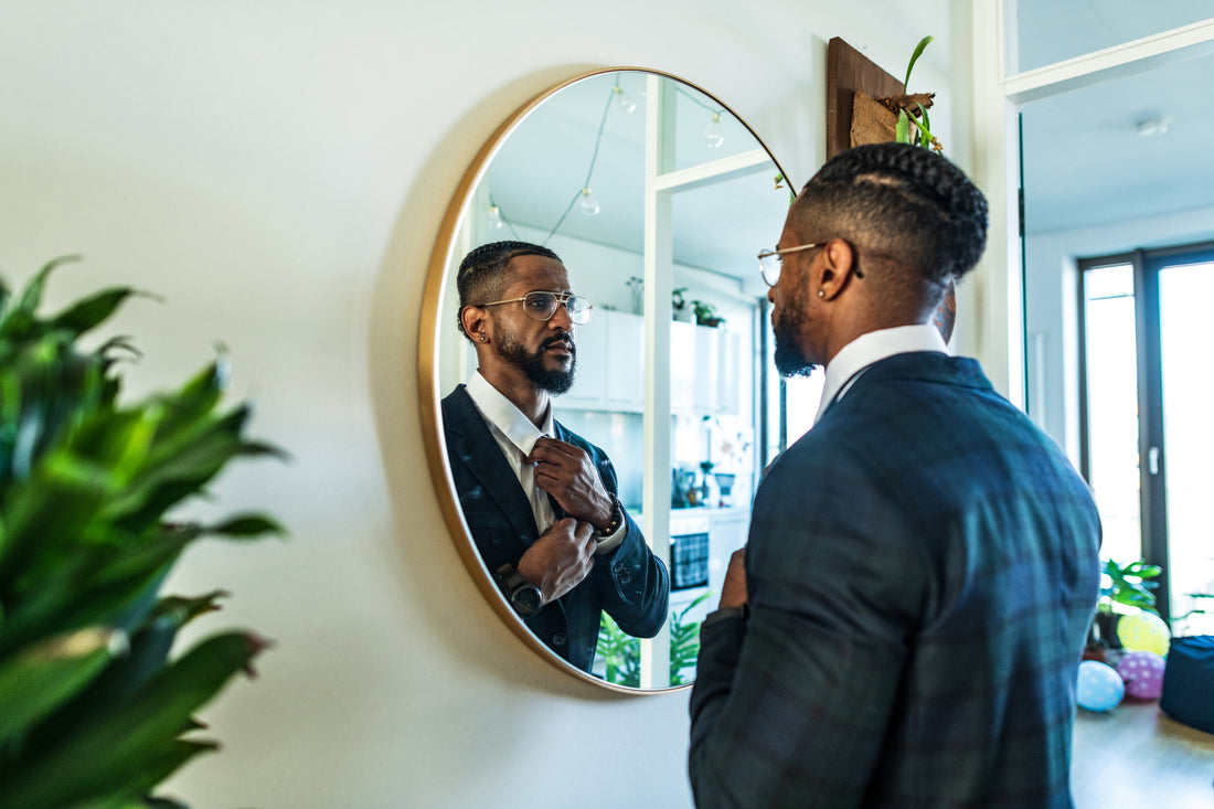 man looking in a stylish mirror in his house