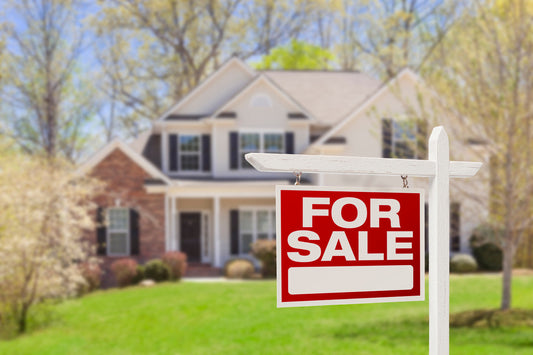 home with a 'for sale' sign in the front yard