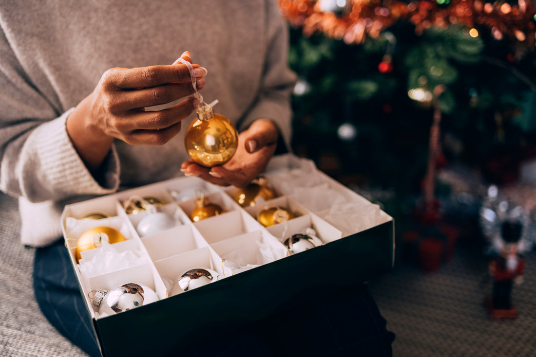 woman organizing ornaments and storing holiday decor
