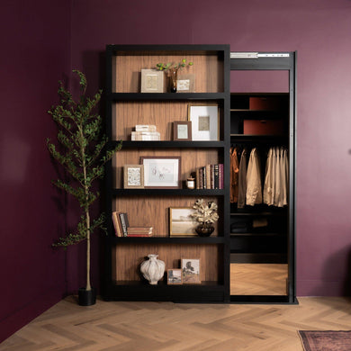 Murphy Door® hidden bookcase, black frame and wood shelves with decor, slides to reveal a closet in a plum room.