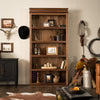 Murphy Door® wooden bookcase with western decor, featuring rich walnut finish, rustic accessories and cowboy-themed items against cream walls.