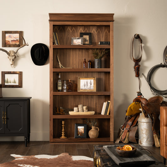 Murphy Door® wooden bookcase with western decor, featuring rich walnut finish, rustic accessories and cowboy-themed items against cream walls.