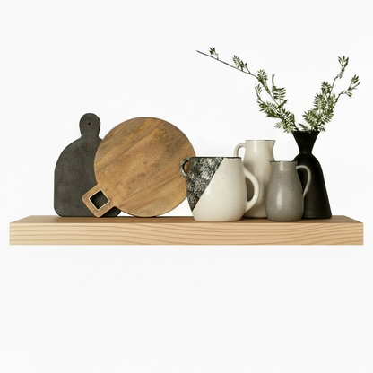 Stylish wooden shelf displaying Murphy Door® cutting boards, ceramic pitchers, and a black vase with delicate greenery.