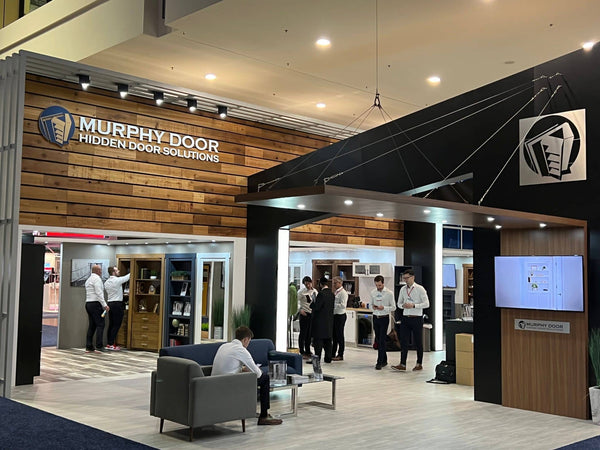 Murphy Door® exhibit featuring hidden bookcase doors integrated into modern wooden and black wall designs.