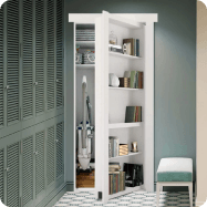 Murphy Door® white bookshelf hidden door, partially open to reveal storage space, with books and decorative items on shelves, against teal wall.