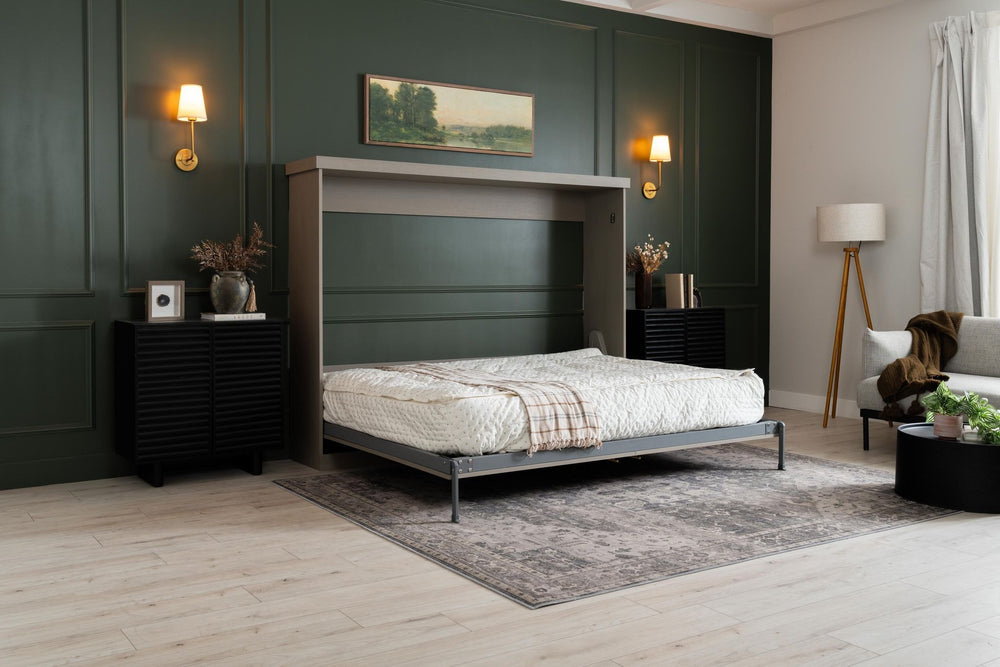 Murphy Door® wall bed with deep green panel background, wood-frame design, and stylish bedroom accents including sconces and area rug.