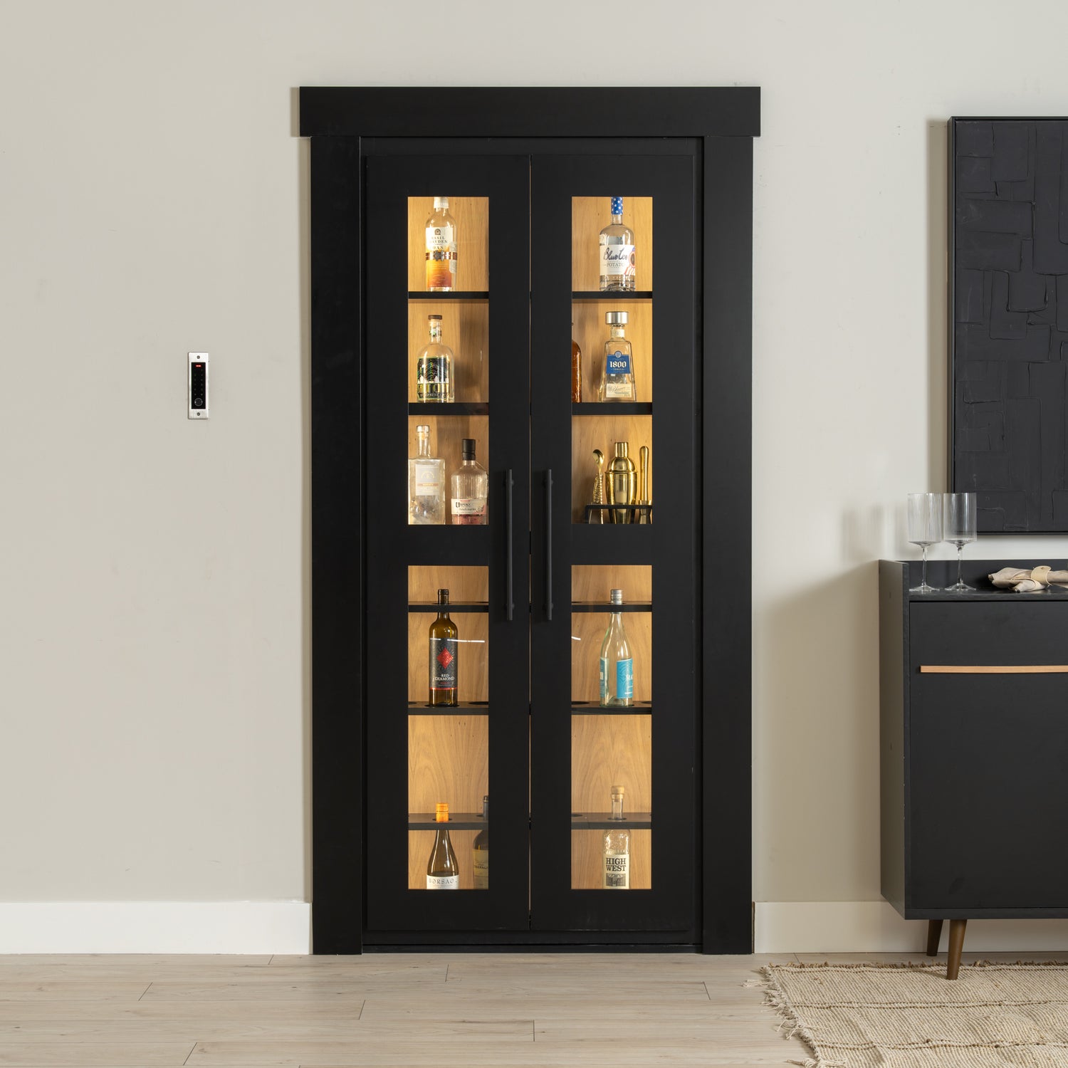 Murphy Door® black liquor cabinet with glass panels, wooden interior shelving, displaying bottles and bar accessories.