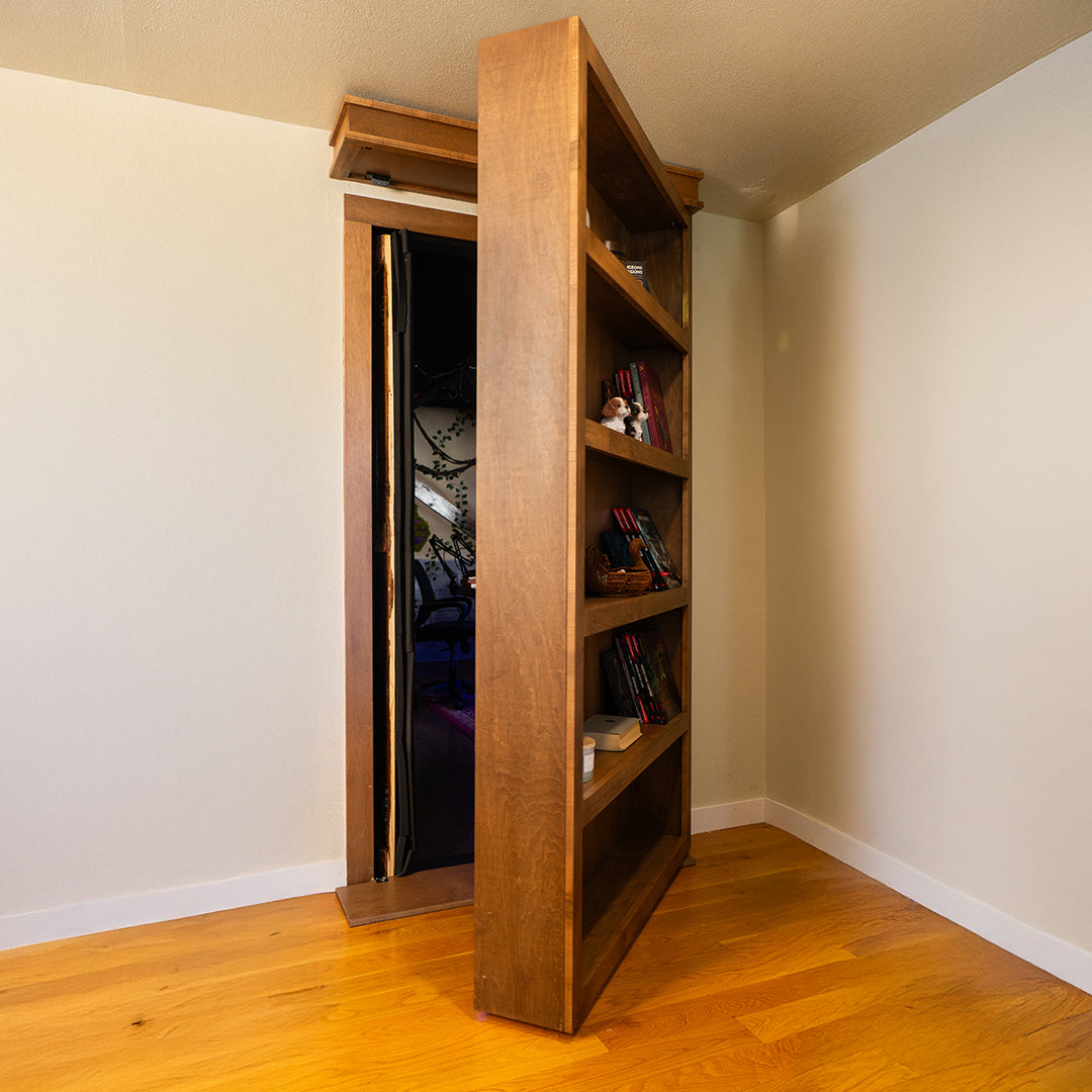 Murphy Door® wooden bookcase door in light oak finish, partially open to reveal hidden room entrance, mounted on hardwood flooring.