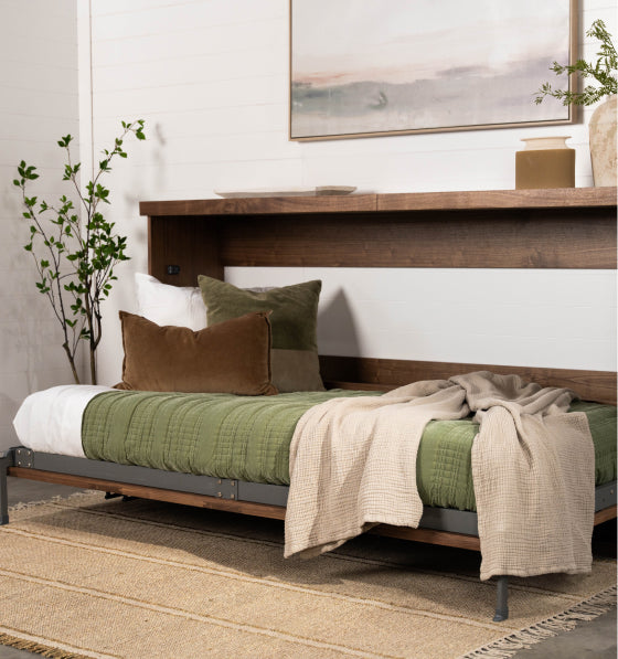 Murphy Door® wooden daybed with green quilted mattress, brown pillow, and beige throw blanket on natural jute rug.