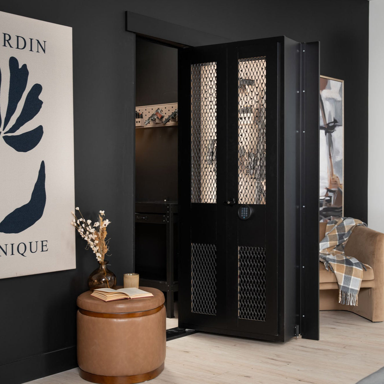 Murphy Door® black metal hidden door with mesh panels and digital lock, featuring elegant design in modern interior with tan ottoman.