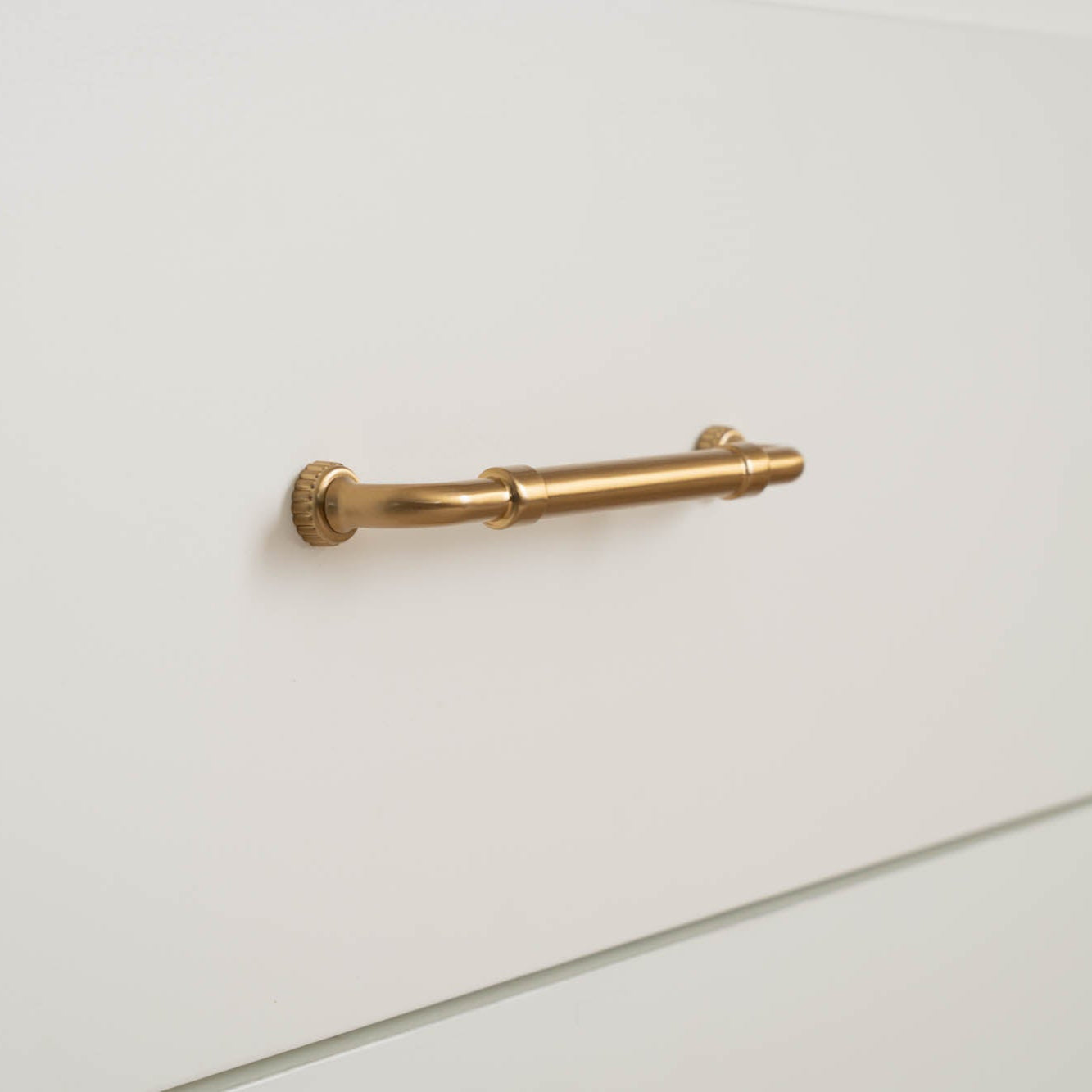 Brass hardware pull handle from Murphy Door® featuring a sleek, cylindrical design with decorative knurled end caps.