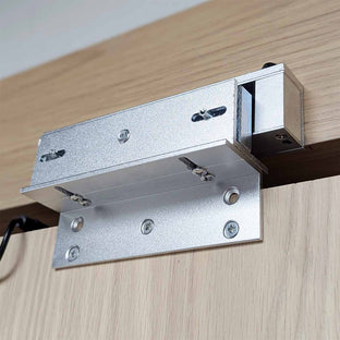 Murphy Door® silver metal bracket hardware for hidden door installation, mounted on light wood with precision screws.