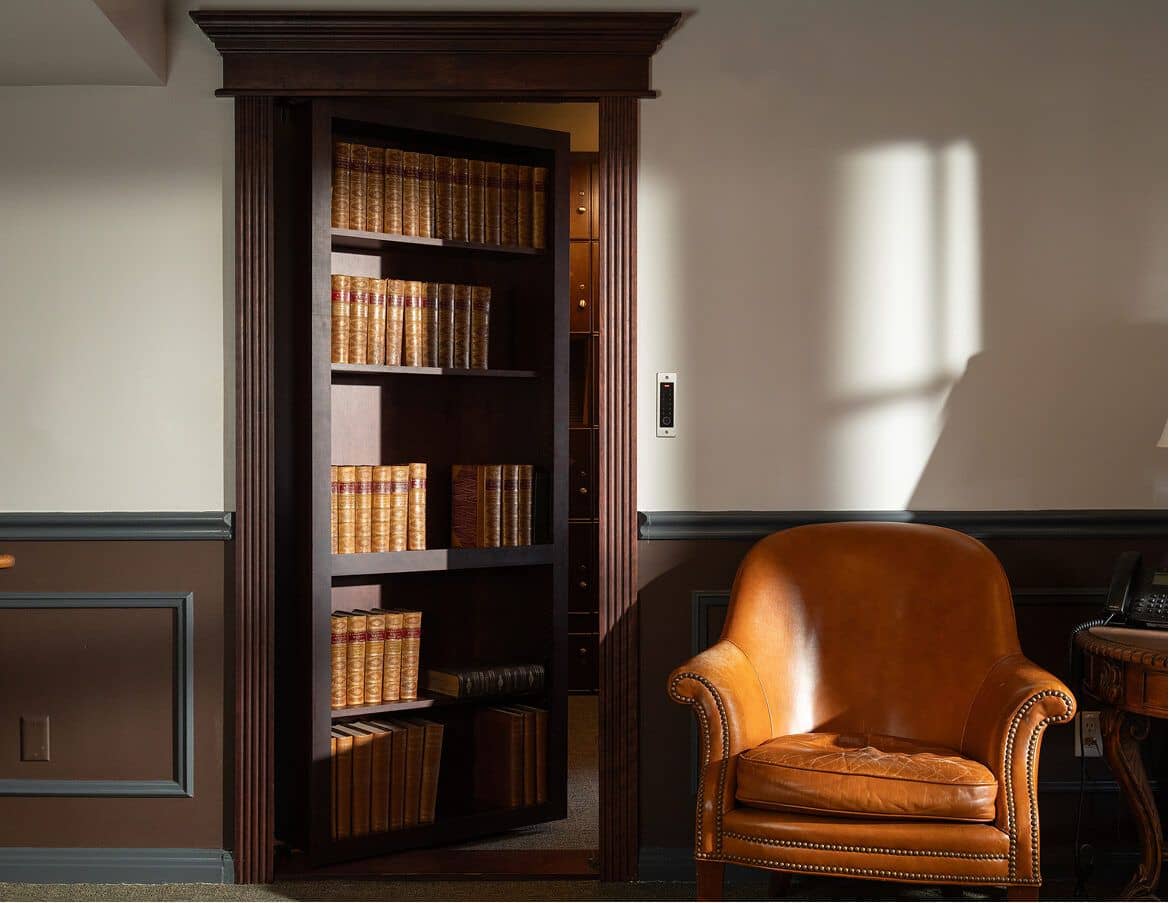 Flush mount hidden bookcase door sitting level with a panelled wall