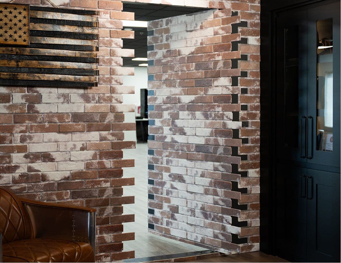 Hidden panel door open in an exposed brick wall