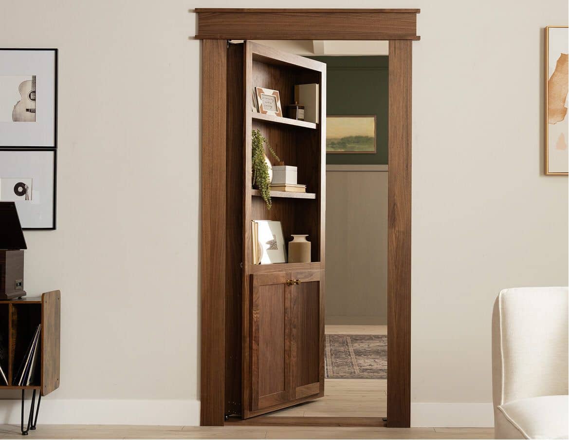 Mid-century walnut hidden bookcase door standing open in a living room