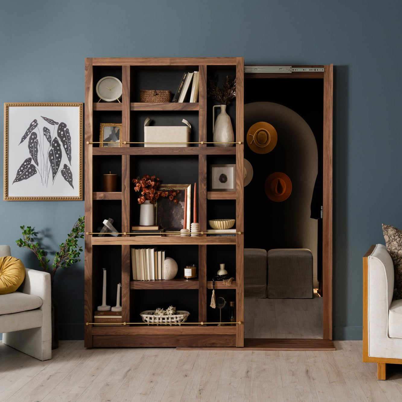Murphy Door® walnut bookshelf with sliding door, displaying decor items on blue wall, functional room divider with hidden doorway.