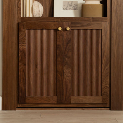 Murphy Door® walnut cabinet with fluted doors, brass knobs, and elegant wooden frame. Decorative items displayed on top shelf.
