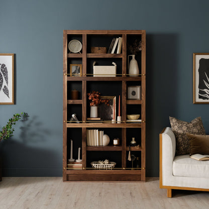 Murphy Door® wooden bookshelf with rich walnut finish against blue-gray wall, displaying decorative items in stylish modern living room.