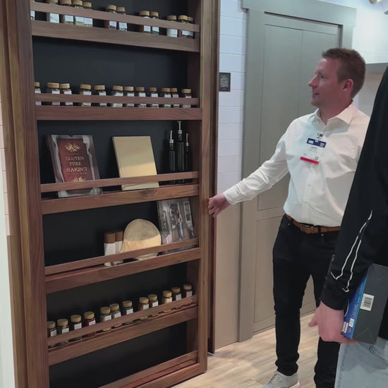 Murphy Door® Slideaway Murphy Bookcase, a flush mount bookcase door, slides open, revealing hidden pantry space with spices.