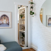 White brick wall with a Murphy Door®️ Bookcase Door.